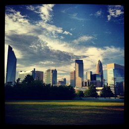 Several buildings in distance veiwed from a park. CC BY 2.0 license credit: "Charlotte, NC - Charlotte, NC" by Desiree Kane is licensed under CC BY 2.0.
