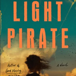 book cover image: individual with hair blown by wind, from behind looking at cloud. Title: The Light Pirate Author: Lily Brooks-Dalton
