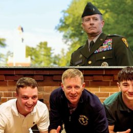 top of image: man, BG Bill McCollough '91 (view of head from chest up) in military uniform. bottom of image: same individual, between young man in white polo shirt and another young man in green polo shirt.