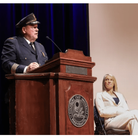 Retiring Fitchburg Police Chief Ernest F. Martineau speaks during the swearing-in ceremony for his replacement, Police Chief Steve Giannini, who began Feb. 1, 2025, with Fitchburg Mayor Samantha Squailia, right.