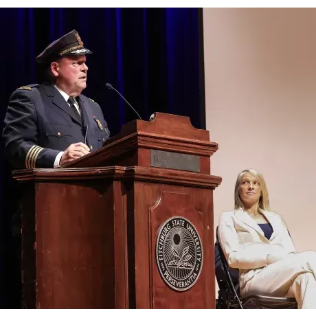 Retiring Fitchburg Police Chief Ernest F. Martineau speaks during the swearing-in ceremony for his replacement, Police Chief Steve Giannini, who began Feb. 1, 2025, with Fitchburg Mayor Samantha Squailia, right.