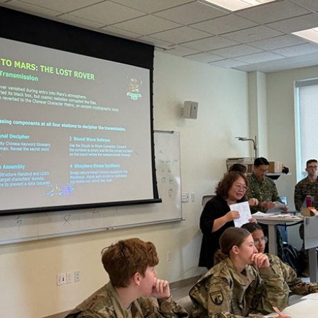 Cadets and other participants gather in a classroom during a Mission to Mars cybersecurity presentation.