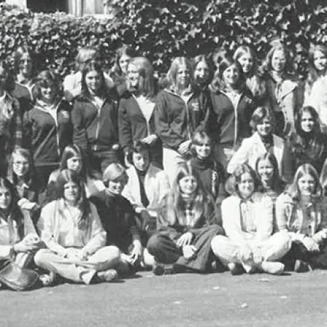 A large group of people pose together outdoors in a black-and-white photograph.