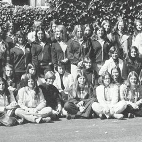 A large group of people pose together outdoors in a black-and-white photograph.