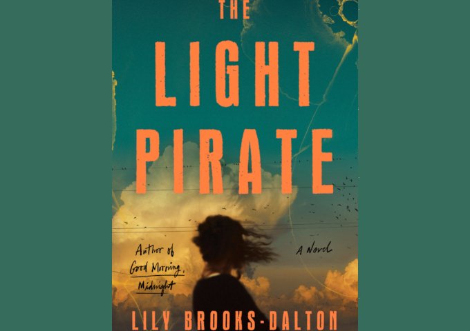 book cover image: individual with hair blown by wind, from behind looking at cloud. Title: The Light Pirate Author: Lily Brooks-Dalton