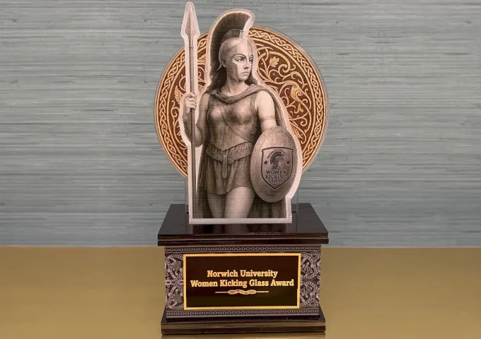 mockup image of an award with goddess athena holding a spear and shield, with words on the award: Norwich University Women Kicking Glass Award.