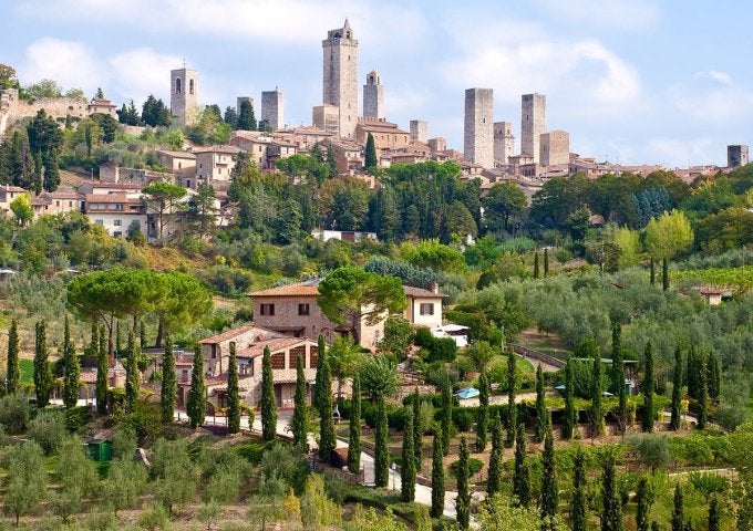 A view of a hillside in the Tuscany region with buildings in far background..