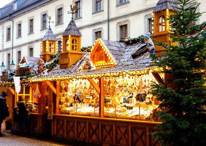 A brightly-lit market stand appears in front of a city block.