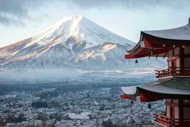 Japan's snowcapped Mount Fuji appears above the valley, with a pagoda style building in frame left.