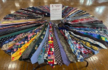 A circle of neckties is seen on a round table with a placard sign placed in the center of the table. These are items donated by Norwich alumni for Dressing for Success, held Feb. 9-10 at Norwich University.