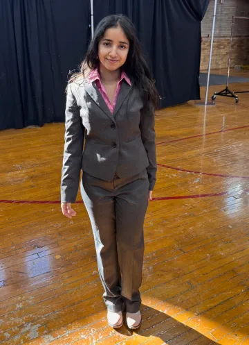 A young woman poses in a formal dress ensemble. They are both wearing formal wear donated to her through Dressing for Success, held Feb. 9-10 at Norwich University.