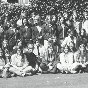 A large group of people pose together outdoors in a black-and-white photograph.